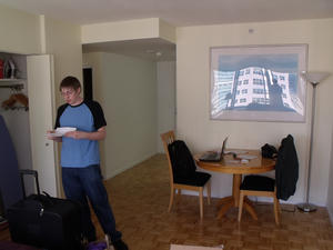 Author in living room of his 2012 apartment for his Amazon Music internship, standing and reading the intro letter