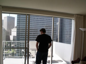 The author in black shirt and blue jeans looking out on the balcony of his second year apartment for his Amazon Music internship