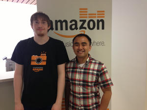 The author and his internship mentor standing in front of an Amazon Music poster